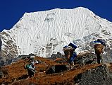 Rolwaling 05 09 Porters Below Tsoboje (Chobutse) From Sangma Kharka The porters start the climb to the Tsho Rolpa from Sanga Kharka with the icy face of Tsobuje (Chobutse) behind.